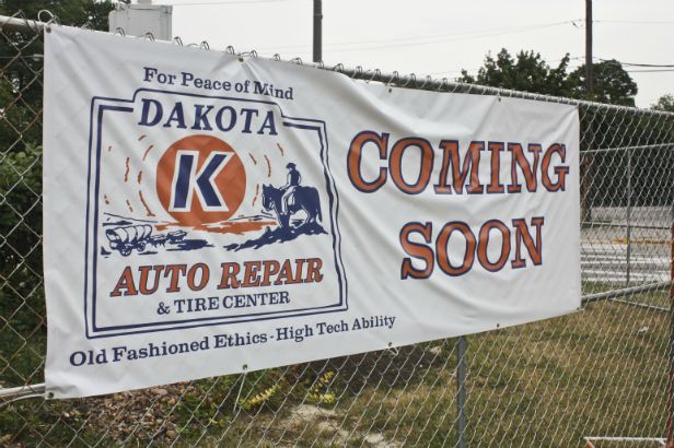Dakota Auto Repair Arlington Heights. Announcing a new location and fence mounted outside the construction site.