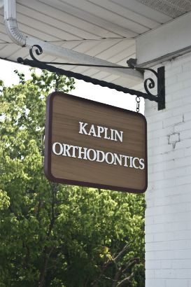 Kaplin Orthodontics Arlington Heights.  Sandblasted wooden sign with painted letters and outline.  Hanging your sign saves space and directs customers from a different angle. 